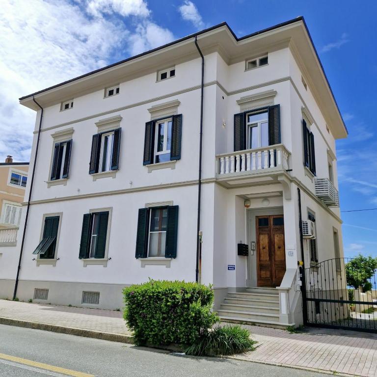 a white house with black windows and a door at Villa dei Limoni in San Vincenzo