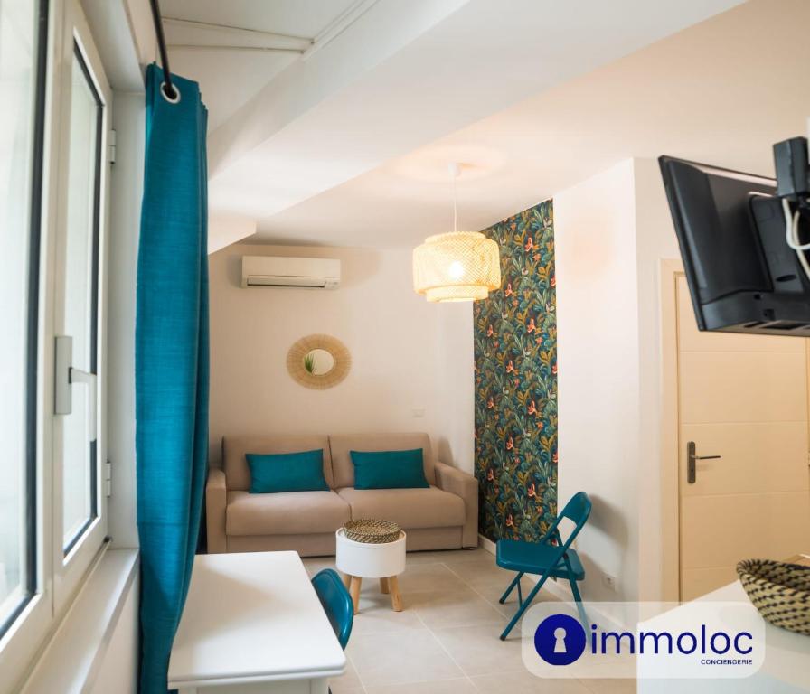 un salon avec un canapé et une télévision dans l'établissement Air-conditioned studio in Fabron, à Nice