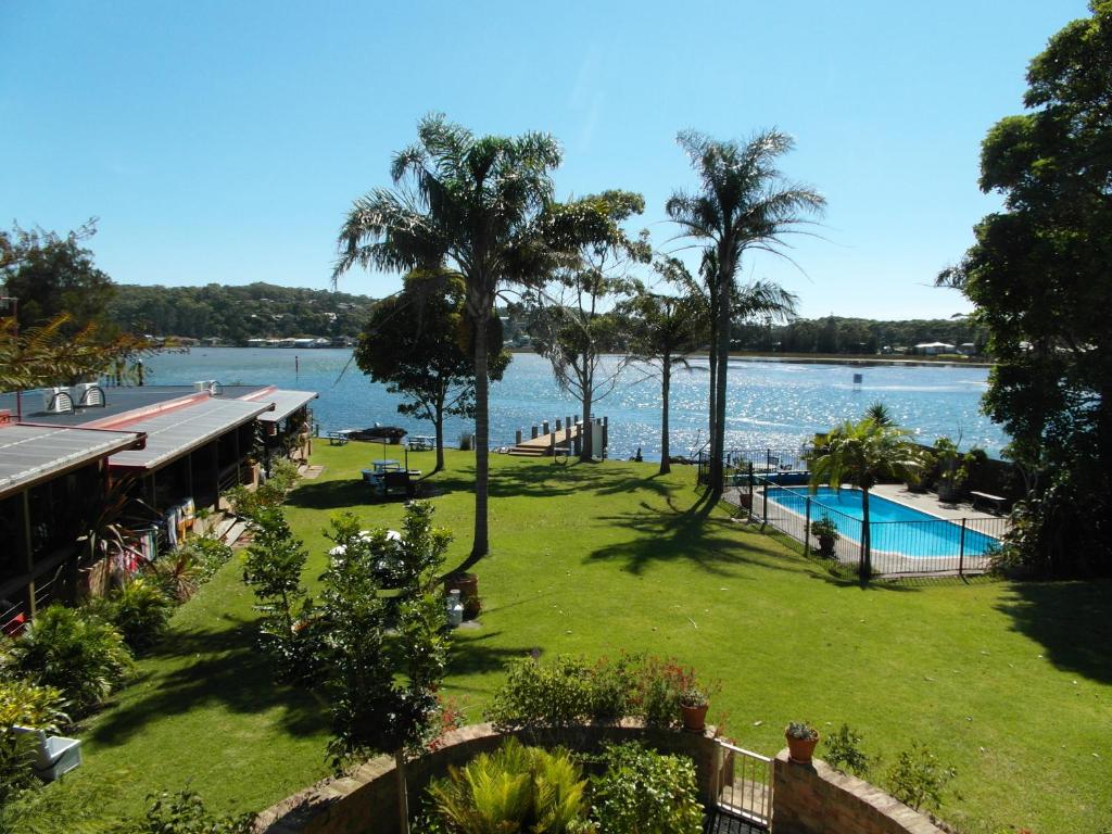 a view of a park with a swimming pool and the water at Lake Edge Apartments in Burrill Lake