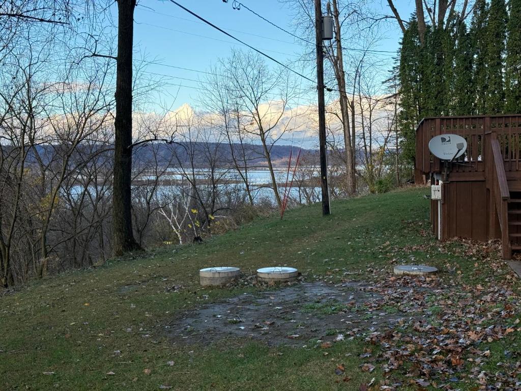 tre pietre nell'erba con vista sull'acqua di Bosco Bluff Cottage a Lansing