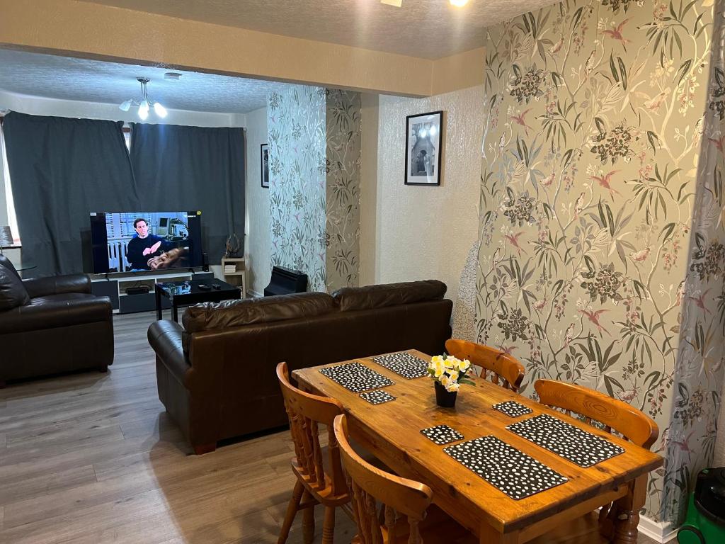 ein Wohnzimmer mit Tisch und Couch in der Unterkunft Five Oaks House- Entire 3 Bedroom House for Family & Contractors with up to 5 sleep- NO PARTIES ALLOWED in Willenhall