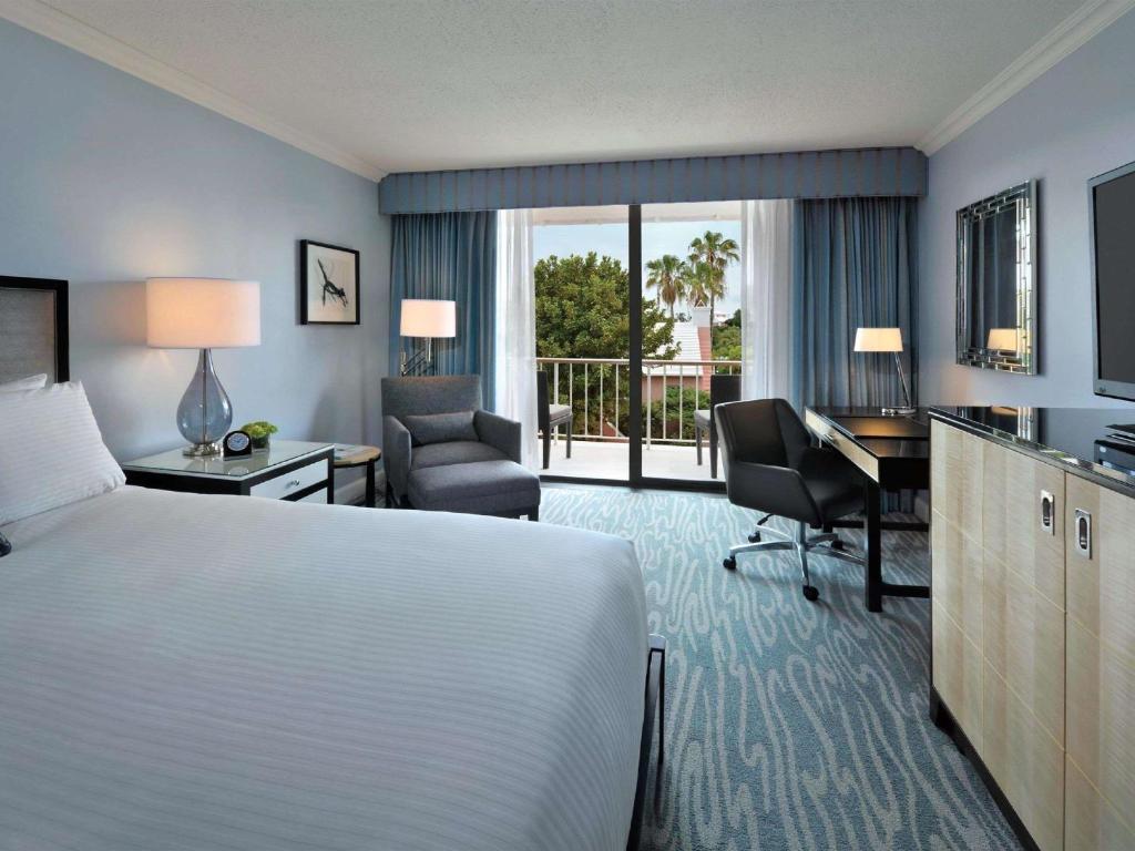 a hotel room with a bed and a desk and chair at Hamilton Princess & Beach Club A Fairmont Managed Hotel in Hamilton