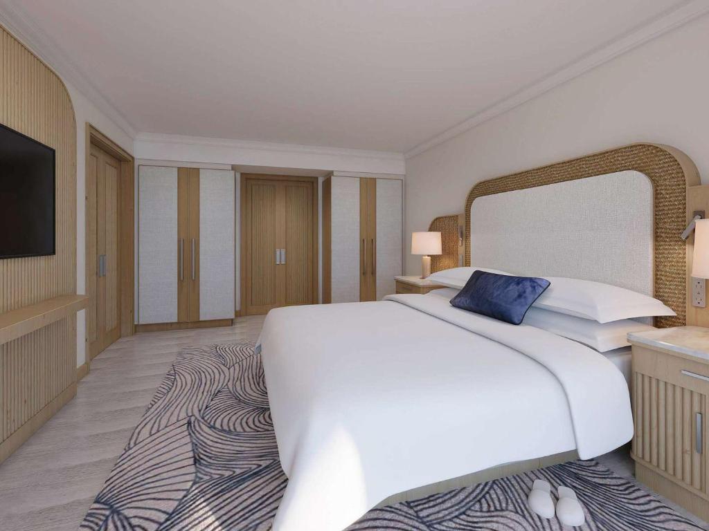 a bedroom with a large white bed and a large mirror at Hamilton Princess & Beach Club A Fairmont Managed Hotel in Hamilton