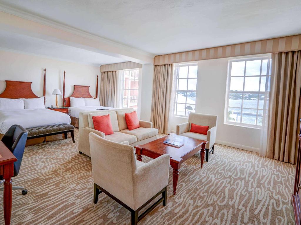 a hotel room with two beds and a living room at Hamilton Princess & Beach Club A Fairmont Managed Hotel in Hamilton