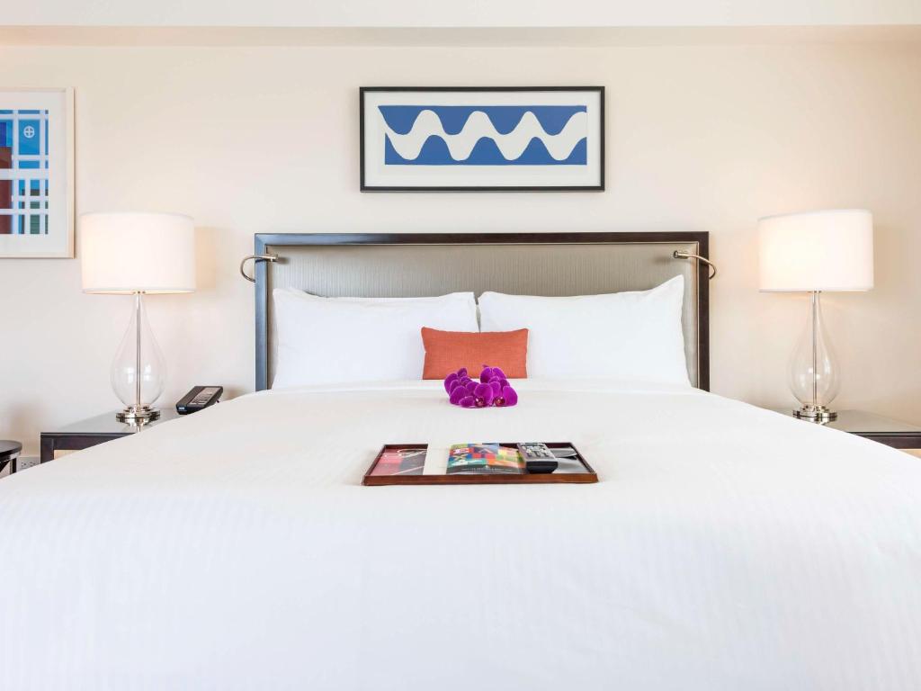 a hotel room with a bed with a magazine on it at Hamilton Princess & Beach Club A Fairmont Managed Hotel in Hamilton