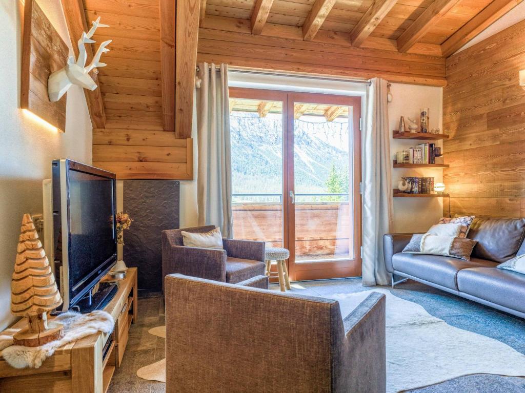 un salon avec un canapé, une télévision et une fenêtre dans l'établissement Duplex vue panoramique Proche pistes Garage prive, à Montgenèvre