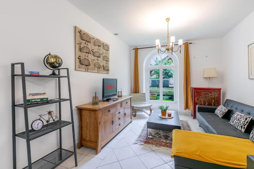 un salon avec un canapé et une télévision dans l'établissement L'authentique au coeur de Paris, à Paris