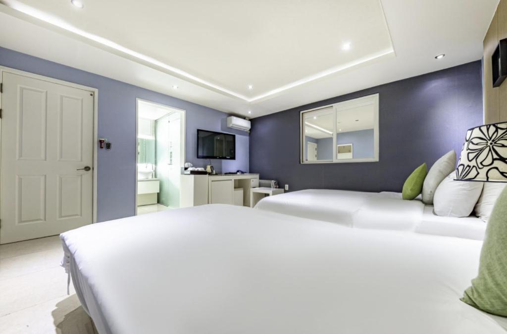 Postel nebo postele na pokoji v ubytování Sangmu Nemo Hotel