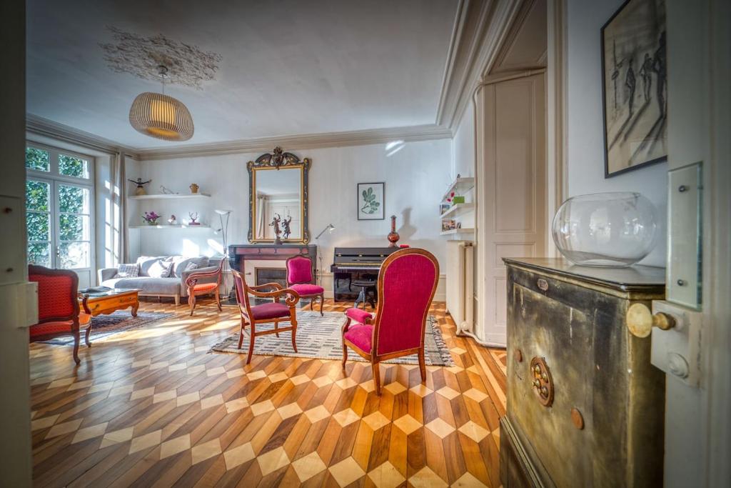 - un salon avec des chaises rouges et un miroir dans l'établissement R'Apparts T4 Le Prieuré, à Grenoble