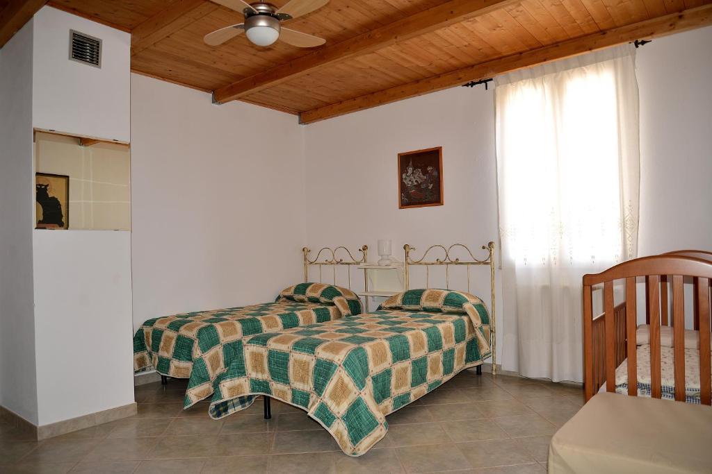 1 dormitorio con 2 camas y techo en B&B S'Incontru en Galtellì