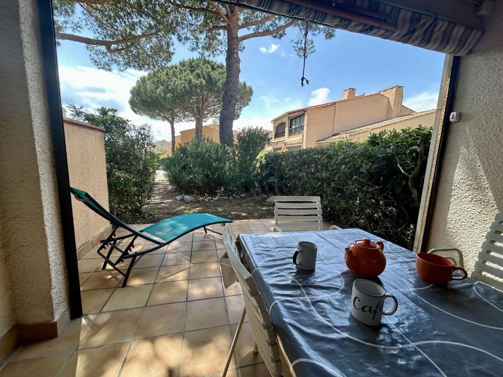 une table avec une théière dessus sur une terrasse dans l'établissement Studio Rez-de-Chaussée à Saint-Cyprien avec Terrasse et Parking - FR-1-225D-224, à Saint-Cyprien