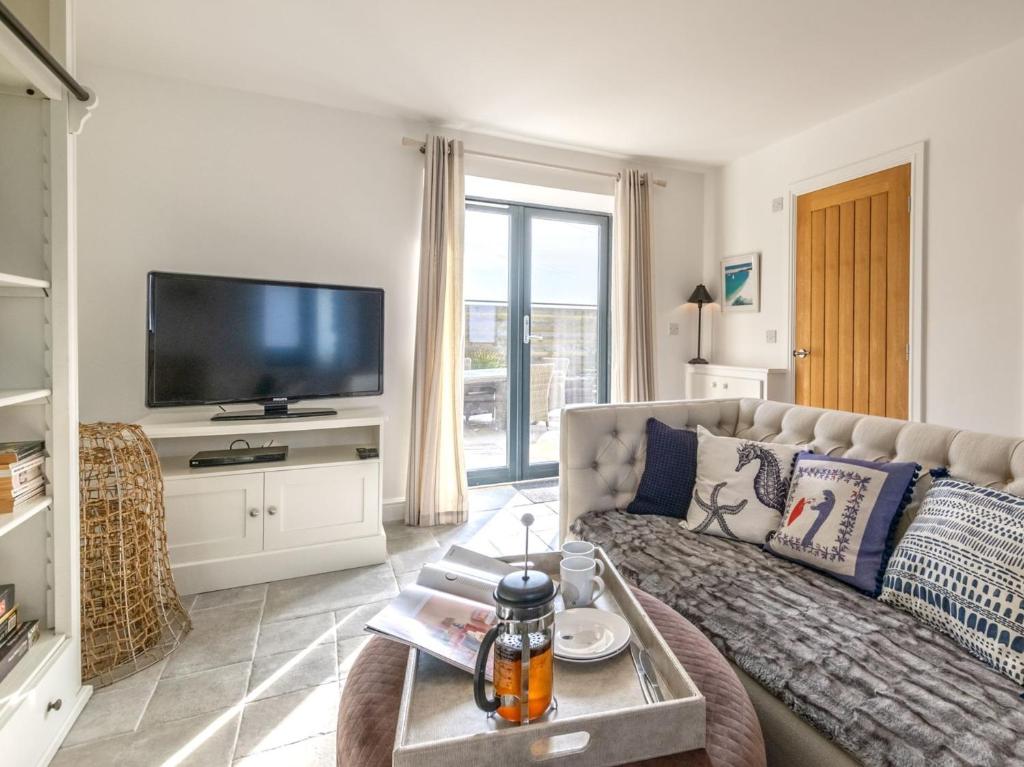 a living room with a couch and a tv at 2 Bed in Cemaes Bay 77640 in Llanfechell