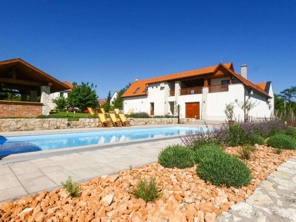 a villa with a swimming pool in front of a house at Bodrog Borműhely Vendégház in Bodrogkisfalud