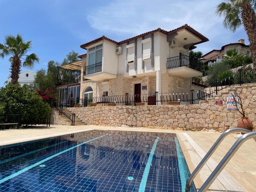 a house with a swimming pool in front of a house at Monix Homes-Villa Magic Garden in Kaş