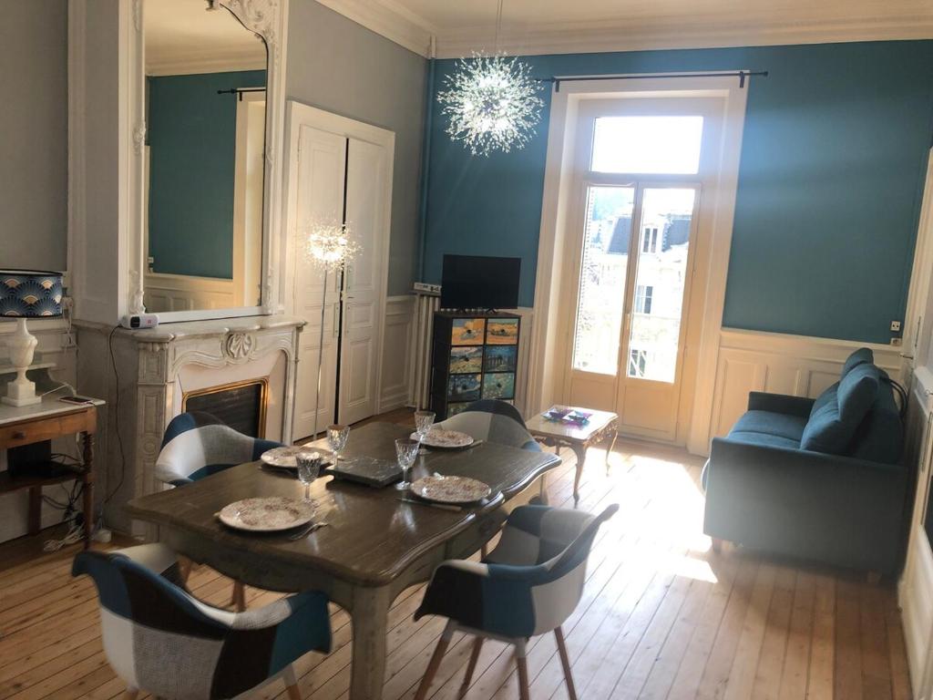 un salon avec une table et des chaises dans l'établissement Appartement T2 52 m2 l'Ambassadeur centre-ville 1 chambre balcon, à Aix-les-Bains
