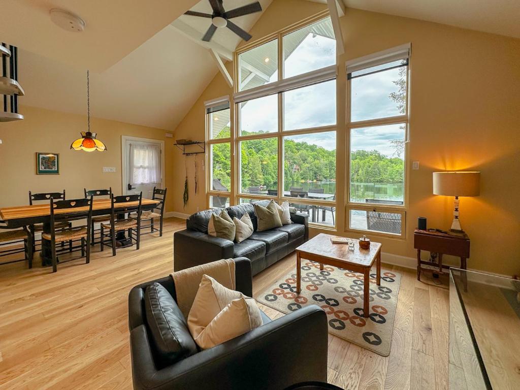 a living room with a couch and a table at Le Mimosa 32 nights min ExitChalets Lake in Morin Heights