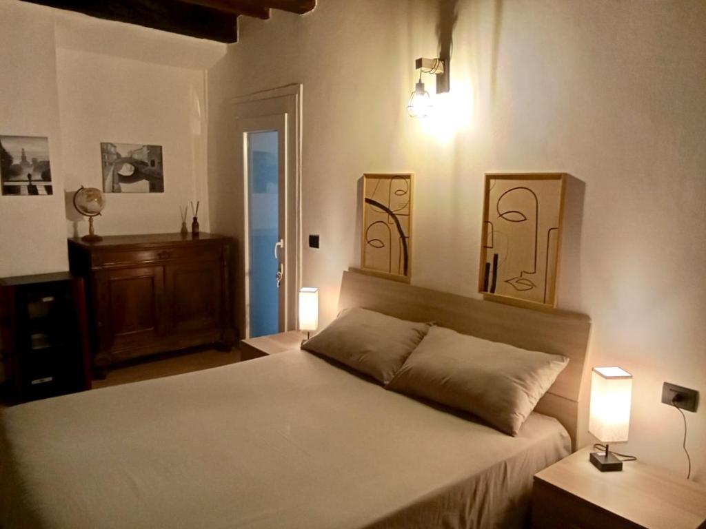 a bedroom with a bed and two lights on the wall at Casa Giannina in Germignaga