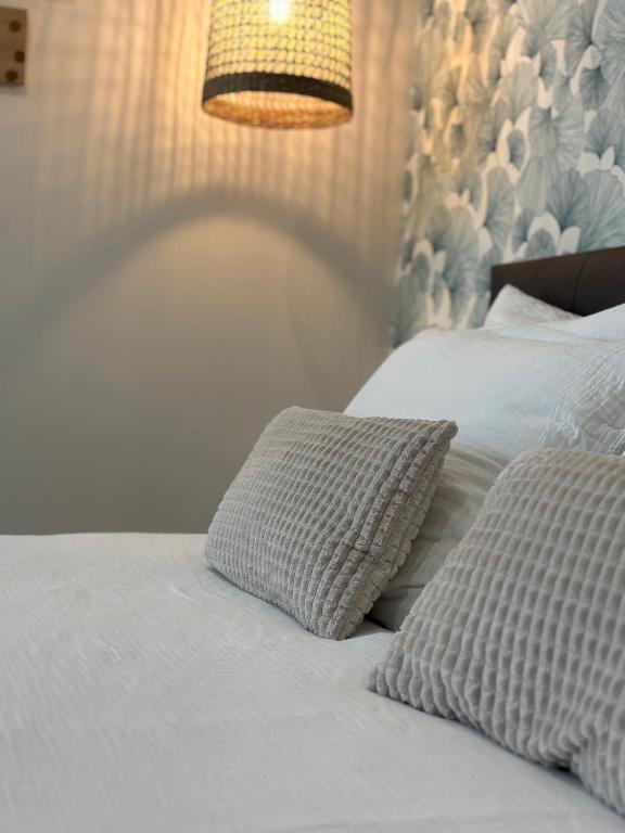 - une chambre avec 2 lits avec des oreillers et une lampe dans l'établissement Le 89 Appartement au calme au centre de Cherbourg, à Cherbourg en Cotentin