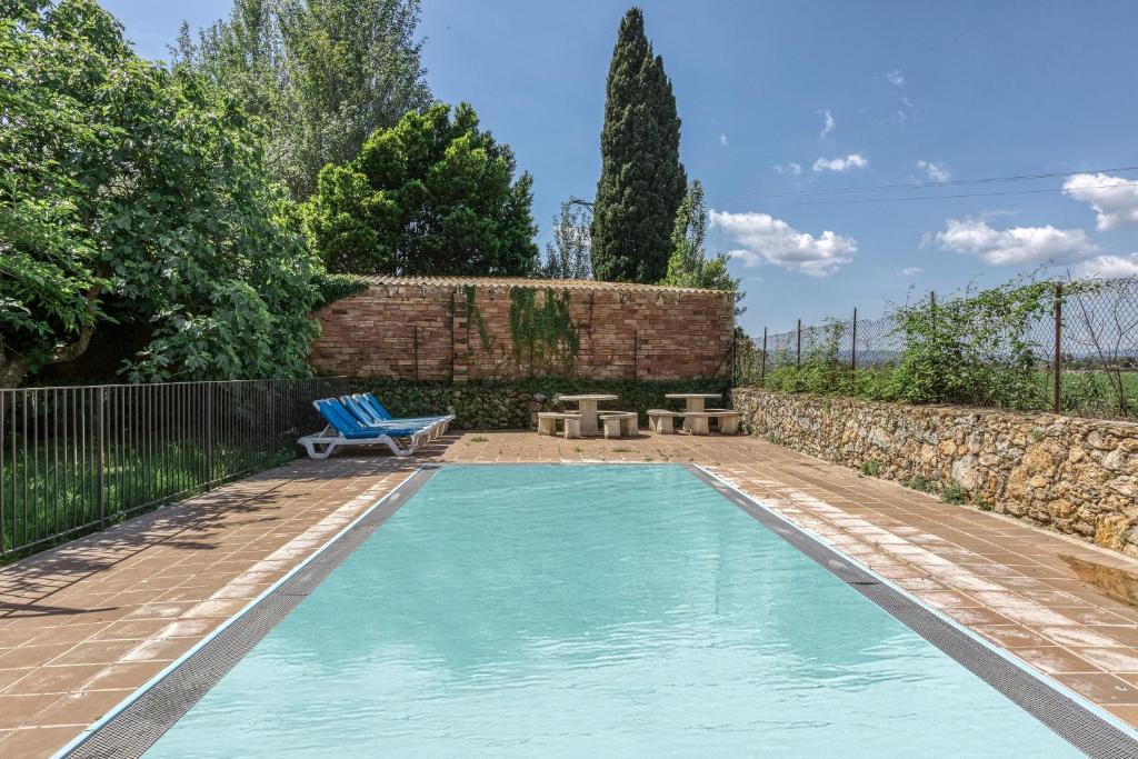 una piscina en un jardín con un banco y una silla en Can Casadellà, en Serra de Daró