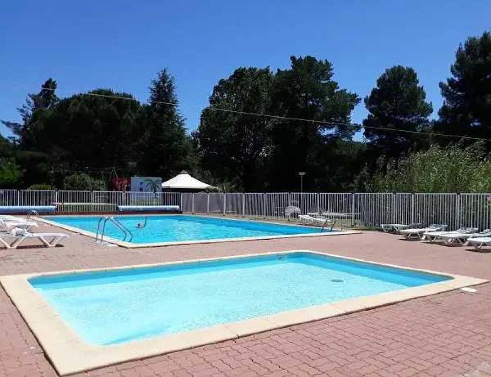 une grande piscine avec deux chaises et une clôture dans l'établissement Cabane 3 étoiles - cca0gbc, à Saint-Jean-Pla-de-Corts