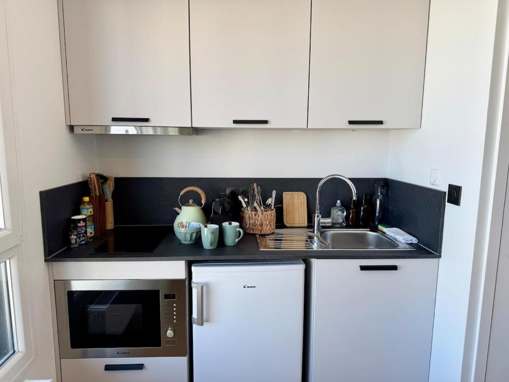 une cuisine avec un évier et un micro-ondes dans l'établissement We Live Inn Sharies Reims - A605, à Reims