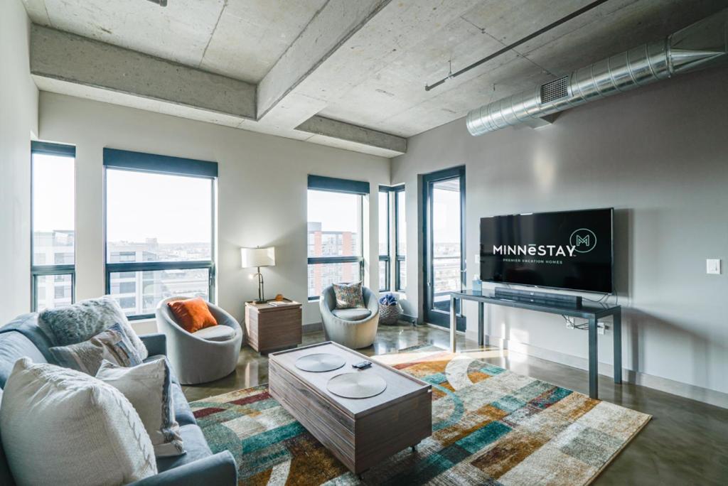 a living room with a television and a couch and chairs at Sable 805 - Two Bedroom in Minneapolis