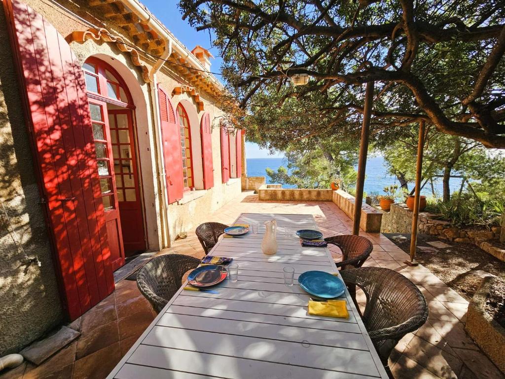 - une table avec des assiettes et de la vaisselle sur la terrasse dans l'établissement Maison de plain-pied avec vue mer, à Saint-Mandrier-sur-Mer