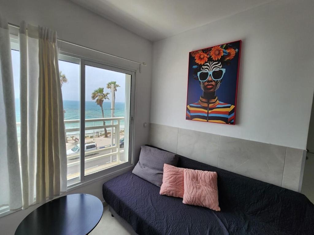 a living room with a couch and a large window at Premium 2BR Sea View Apartment Bat Yam in Bat Yam