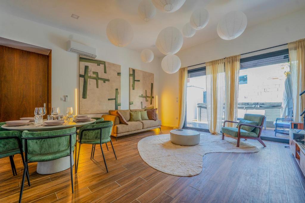 a living room with a table and green chairs at Maison La Fontaine in Gières