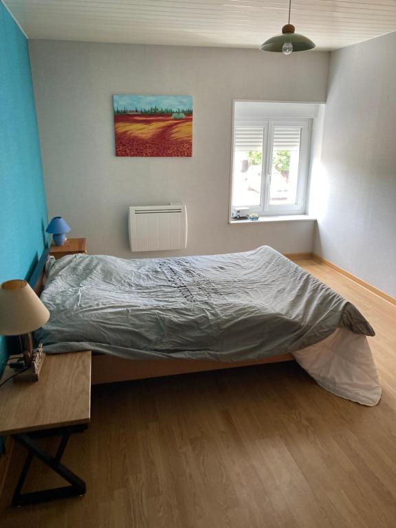 une chambre avec un lit, une table et une fenêtre dans l'établissement Location, à La Celle-sous-Gouzon