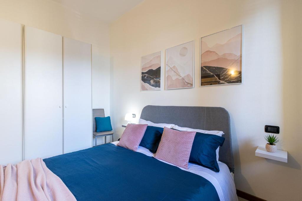 una camera da letto con un letto con cuscini blu e rosa di [Sweet Arona] Beautiful Apartment, Netflix - Wi-Fi ad Arona