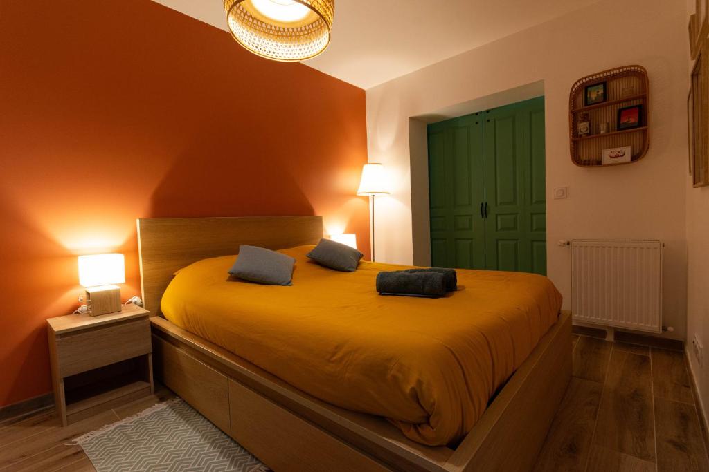 a bedroom with a bed with yellow sheets and a green door at La Maisonnette - Disneyland Paris in Chanteloup-en-Brie