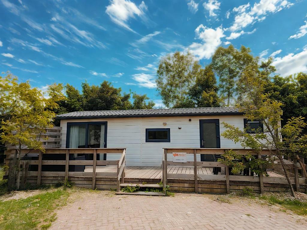 a white house with a wooden fence at Familie Chalet Oostkapelle OK30 in Oostkapelle
