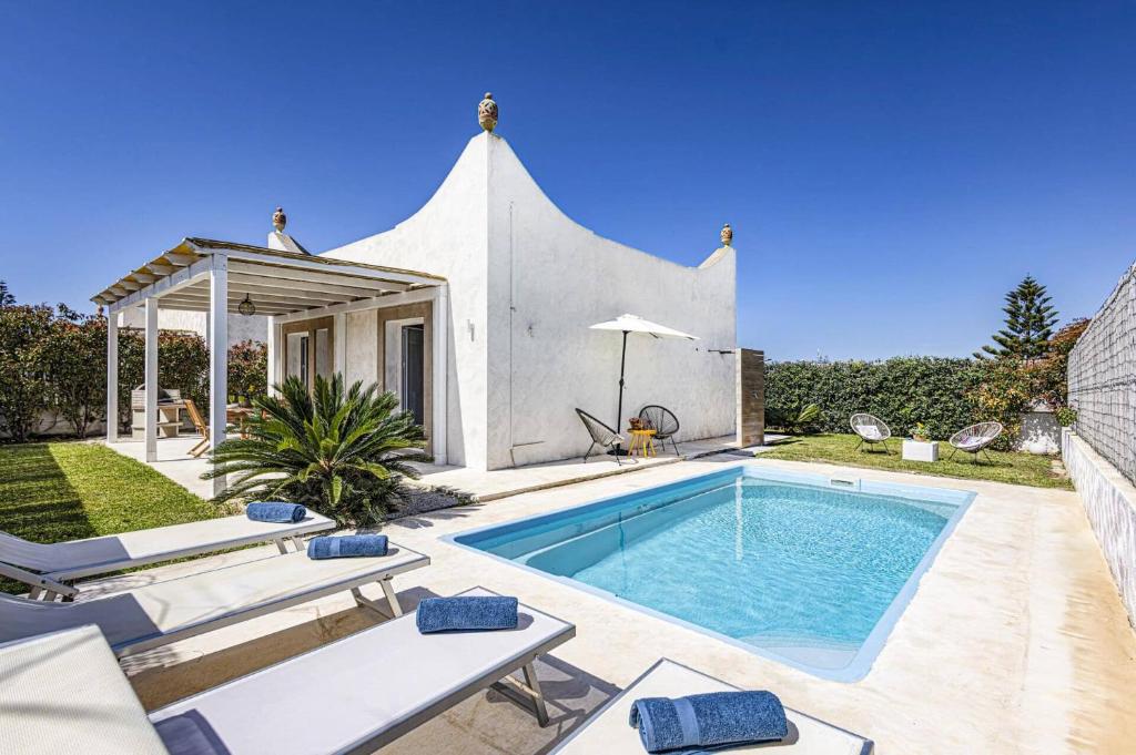 une piscine dans l'arrière-cour d'une maison dans l'établissement Villa Luce by Villa Plus, à Santa Maria Del Focallo