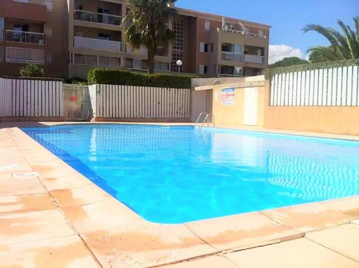 une grande piscine bleue devant un immeuble dans l'établissement Piscine, plages à proximité, internet et parking privé, à La Seyne-sur-Mer
