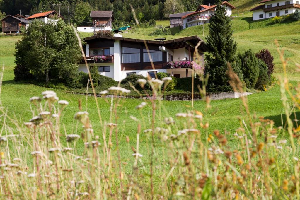 ein Haus auf einem Hügel mit Gras in der Unterkunft Apart Adele in Arzl im Pitztal