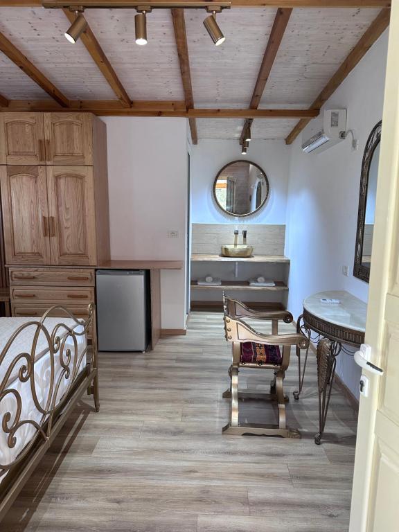 a room with a bed and a table and a sink at Nashos Bungalows in (( Spile ))