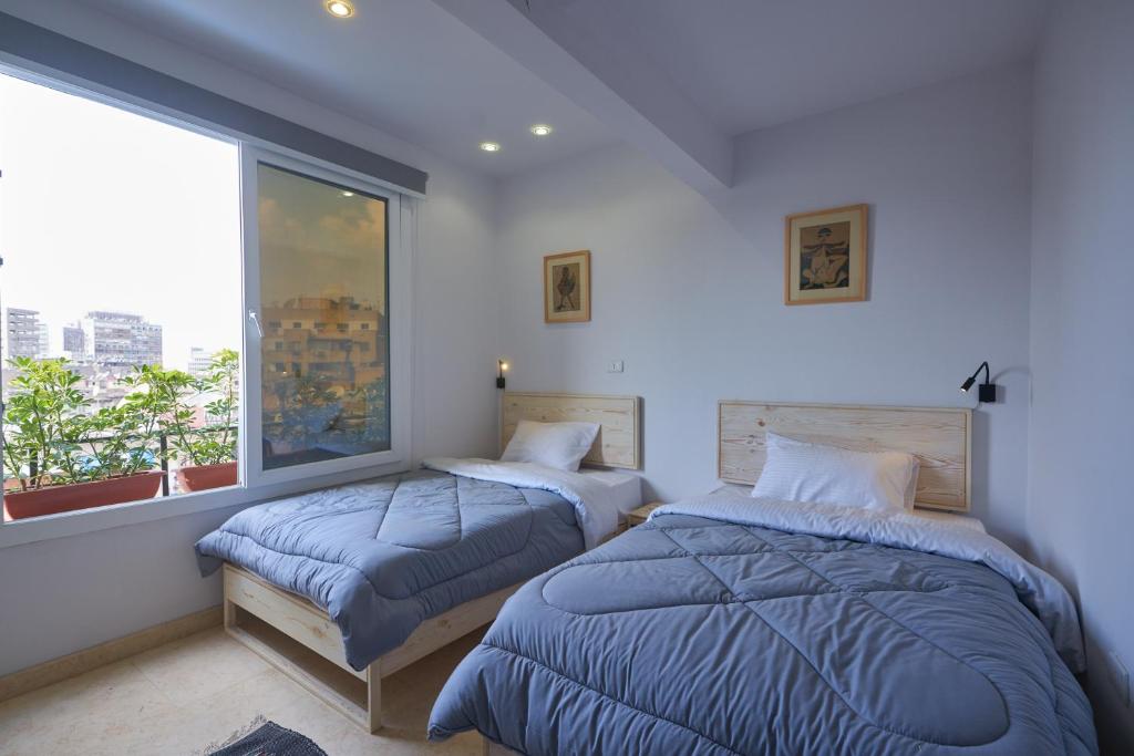 una camera da letto con due letti e una finestra di Madina Hostel a Il Cairo