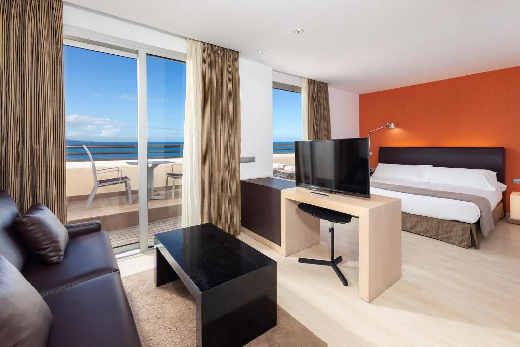 a hotel room with a bed and a desk with a television at Hotel Cristina by Tigotan Las Palmas - Adults Only in Las Palmas de Gran Canaria
