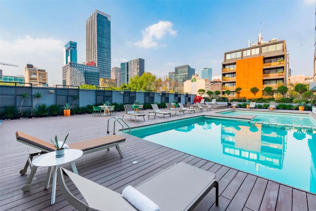 a swimming pool on a rooftop with a city skyline at NH Collection Mexico City Reforma in Mexico City