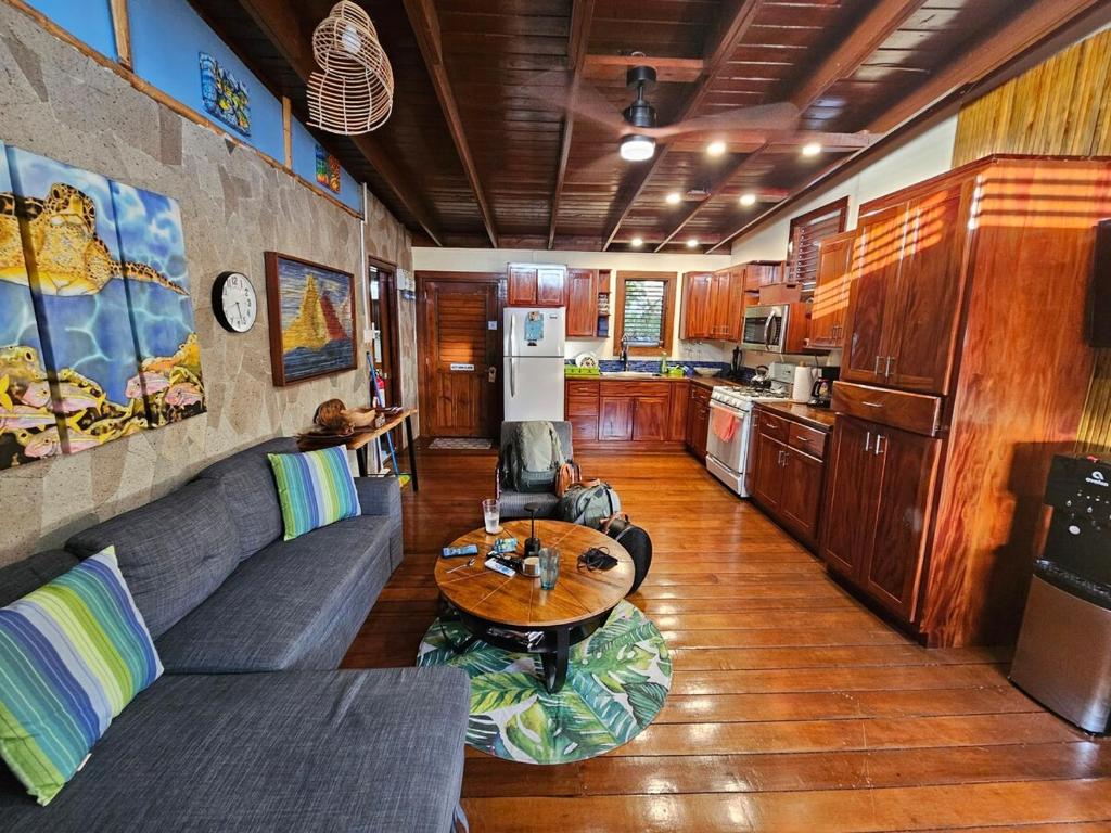 ein Wohnzimmer mit einer Couch und einem Tisch in der Unterkunft Treehouse Hideaway Villa II - Amazing Piton Views in Soufrière