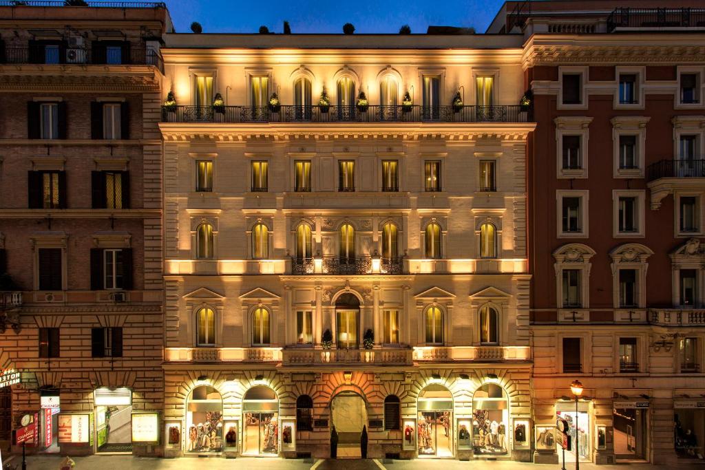 un bâtiment éclairé dans une ville la nuit dans l'établissement Hotel Artemide, à Rome