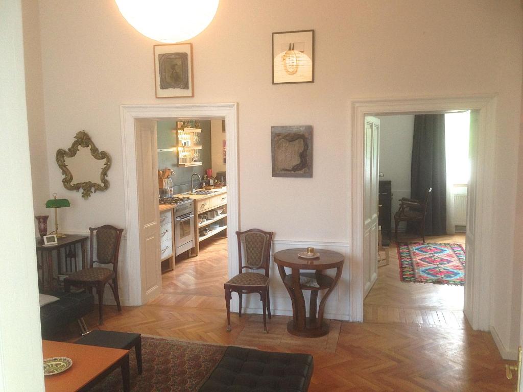 een woonkamer met een tafel en stoelen en een keuken bij Augusta in Cluj-Napoca