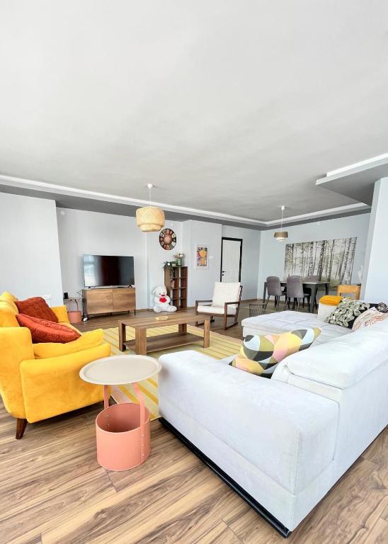 a living room with two white couches and a table at Kaira Homes 3 in Dikmen