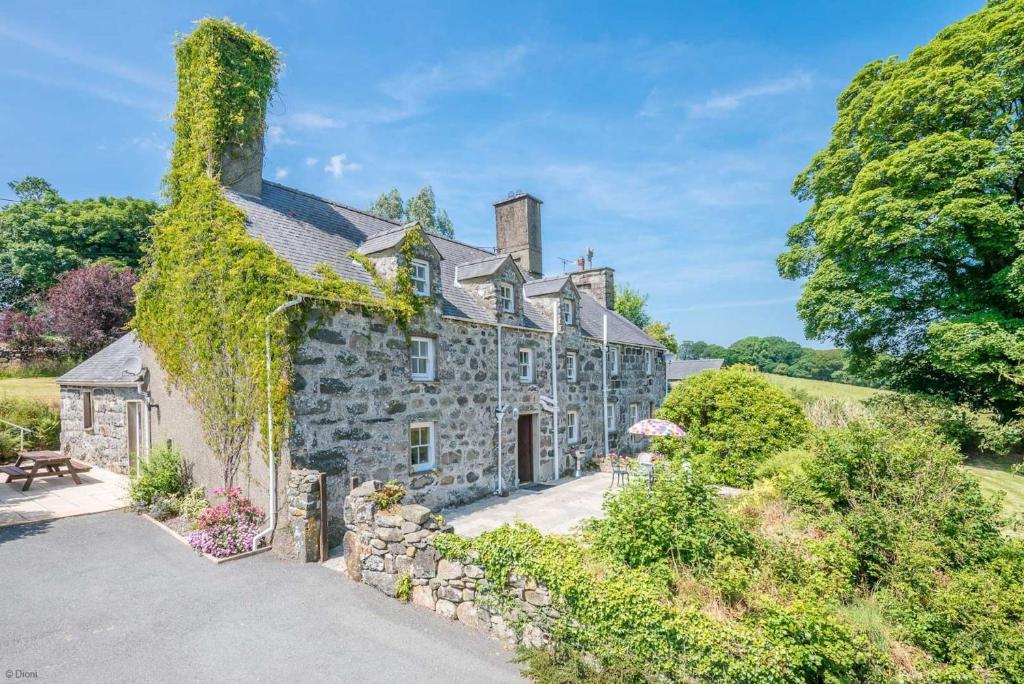 an exterior view of a stone house with ivy at Bwthyn-Betws in Dolbenmaen