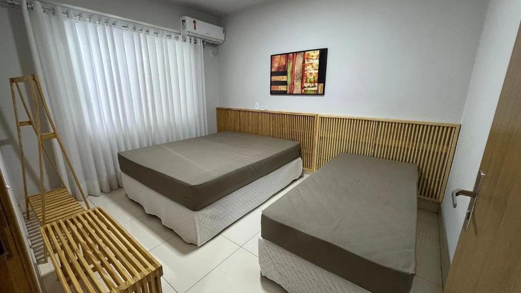 カルダス・ノバスにあるApartamentos The Villeneuve Residenceのベッド2台とベンチがある部屋