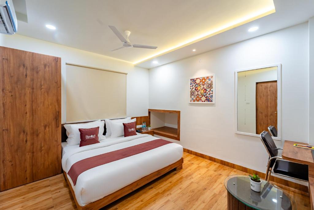 a hotel room with a bed and a desk at Basotel Hotel Indore Vijaynagar in Indore