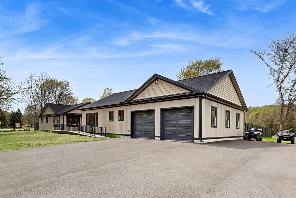 a house with two garage doors in a driveway at The House at the Compound in Fort Ann
