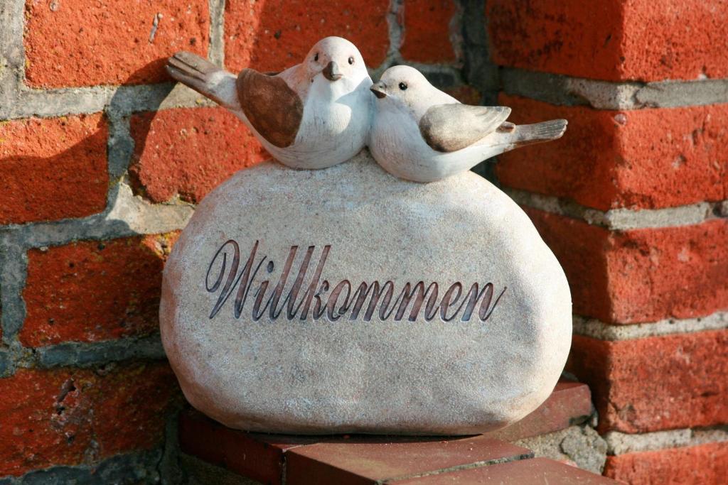 un bonhomme de neige en pierre avec trois oiseaux assis dessus dans l'établissement Bauernhof Urlaub FeWo Nr 2 - 2-Personen, à Schlagsdorf