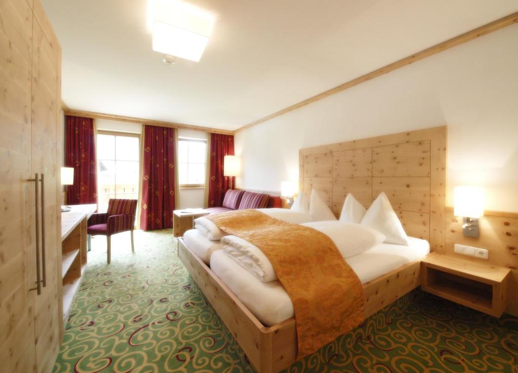 a hotel room with a bed and a desk at Berghotel Alpenklang in Grossarl